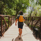 Osprey Daylite™ Backpack Lifestyle Image Walking Across Bridge